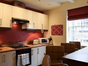 Una cocina con gabinetes blancos y un microondas. en Honeyz Hideaway, en Whitby