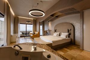 a hotel room with a bed and a tub and a sink at Radisson Resort Ruza Vjetrova in Dobra Voda