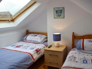a bedroom with two beds and a lamp on a night stand at Oakwood in Bridlington +4 photos