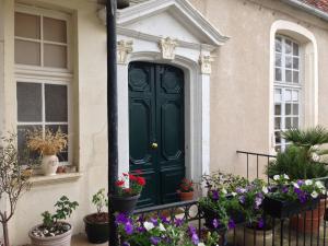 uma porta verde numa casa com vasos de plantas em Maison Colladon em Bourges