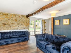 - un salon avec deux canapés en cuir bleu dans l'établissement Castle Cottage, à Castleton