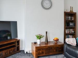 Una sala de estar con televisión y una mesa de café. en Seaforth House, en Bridlington