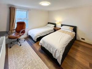 a bedroom with two beds and a chair and a desk at Beach Oasis Cottage - Uk48530 in Margate