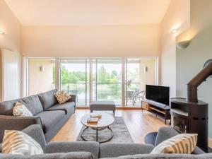 een woonkamer met een bank en een televisie bij Plovers Nest At Lower Mill in Somerford Keynes