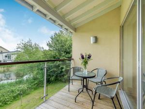 een terras met een tafel en stoelen op een balkon bij Plovers Nest At Lower Mill in Somerford Keynes