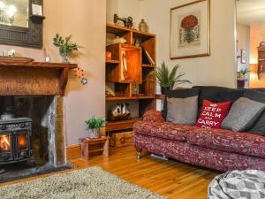 a living room with a couch and a fireplace at Half Pint Cottage in Haworth