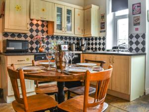 a kitchen with a wooden table with chairs and a table at Half Pint Cottage in Haworth