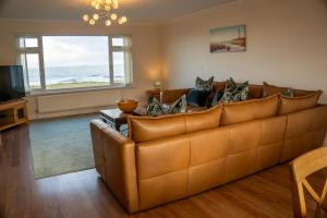 a living room with a couch and a television at Seaview House in Seahouses