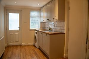 a kitchen with a sink and a washing machine at Seaview House in Seahouses