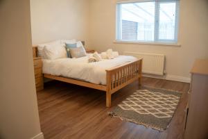a bedroom with a bed with white sheets and a window at Seaview House in Seahouses
