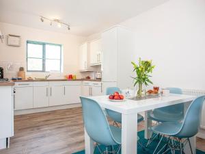 een keuken met een witte tafel en blauwe stoelen bij 4 Water Wheel Apartment in Charlestown