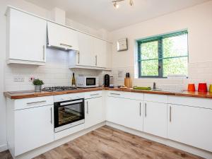 een keuken met witte kasten en een houten vloer bij 4 Water Wheel Apartment in Charlestown