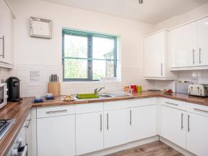 een witte keuken met witte kasten en een spoelbak bij 4 Water Wheel Apartment in Charlestown