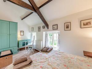 a bedroom with a large bed and a desk at Stable Cottage - 26032 in Wark +7 photos