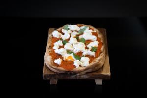 a pizza sitting on top of a wooden cutting board at Warmthotel in Rome