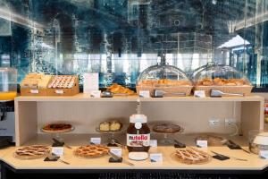 a display case with many different types of pastries at Warmthotel in Rome