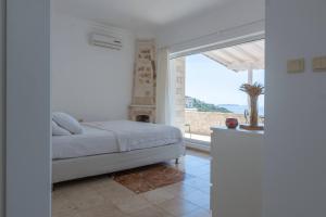 una camera bianca con un letto e una grande finestra di Monix Homes-Villa Deniz - Stunning Seaview a Yarim Adası Altre 47 foto