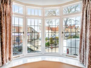 an empty room with large windows looking out onto a street at Bow Cottage in Pickering