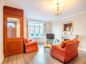 a living room with two chairs and a fireplace at Bow Cottage in Pickering