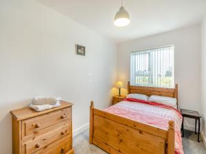 1 dormitorio con cama de madera y vestidor en The Bungalow, en Denby