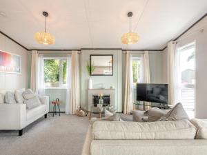 een woonkamer met een bank en een tv bij Tranquil Dawn in Corton