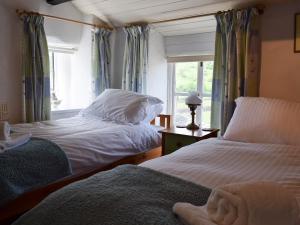 zwei Betten in einem Zimmer mit Fenster in der Unterkunft Foss Gill in Starbotton
