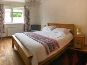 a bedroom with a large bed and a window at Smithy Cottage in Middle Mill +19 photos