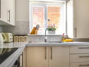 a kitchen with a sink and a window at Ivy Cottage in North Coates +7 photos