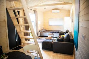 a living room with a couch and a staircase at 3 WIDOKI Kiekrz -domki Tiny House z prywatną plażą i pomostem nad jeziorem Kierskim in Poznań