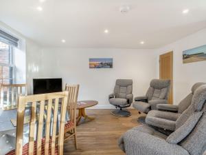 a living room with a couch and chairs and a table at Two Little Ducks in Wells next the Sea