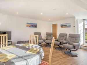 a room with a bed and chairs in it at Two Little Ducks in Wells next the Sea