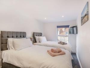 two beds with towels on them in a bedroom at Two Little Ducks in Wells next the Sea