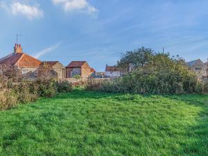 a field of green grass with houses in the background at Two Little Ducks in Wells next the Sea
