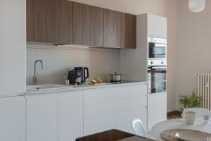 a kitchen with white cabinets and a counter top at Casa Fiore by Vayadù in Savigliano