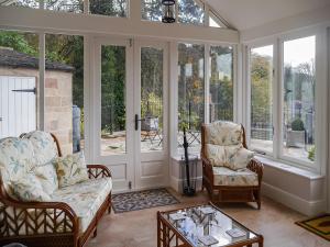 a screened in porch with two chairs and a coffee table at Acacia Cottage in Wirksworth +17 photos