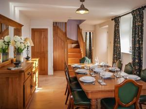 a dining room with a wooden table and chairs at Acacia Cottage in Wirksworth