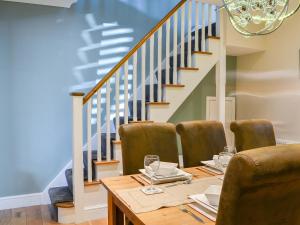 a dining room with a table and chairs and stairs at Lowey's Harbour Cottage in Bridlington