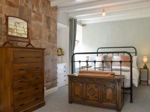 ein Schlafzimmer mit einem Bett, einer Kommode und einem Spiegel in der Unterkunft Beck View Cottage in Staithes