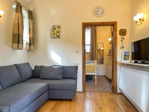 a living room with a couch and a tv at Ravenscliffe Cottage in Tissington