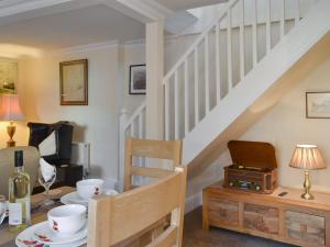 a living room with a staircase with a table and a chair at Benny's Cottage in Hotham +20 photos