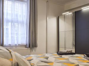 a bedroom with a bed and a mirror and a window at Jet Workers Cottage in Whitby +10 photos