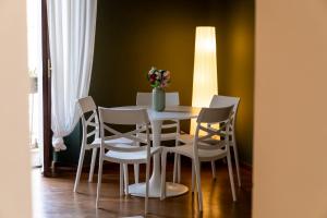 a table and chairs with a vase of flowers on it at LP Apartments - Navigli View in Milan