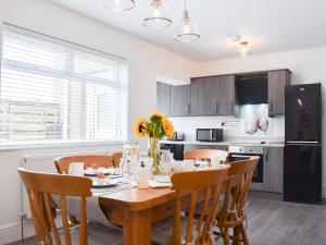 a kitchen with a dining room table and chairs at Wayside in Amble +13 photos