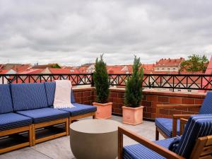 a balcony with blue chairs and a table and buildings at Hotel Reja, a Member of Design Hotels in Klaipėda