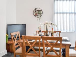 Un comedor con una mesa con sillas y un televisor. en Seaforth House, en Bridlington 28 fotos más