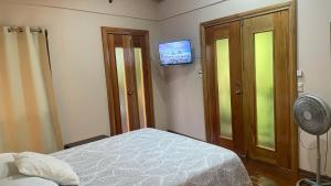 a bedroom with a bed and a tv on the wall at Chilamate Jungle View in Tortuguero