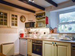 una cocina con armarios amarillos y una ventana en The Old Sweetshop, en Par