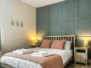 a bedroom with a bed with two towels on it at Alders Cottage in Tansley