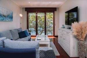 a living room with a couch and a table at Precioso amanecer frente al mar by CABANA Rentals in Cangas de Morrazo