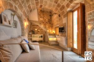 ein Wohnzimmer mit einem Sofa in einem Steingebäude in der Unterkunft G.H.03 Polignano a Mare in Polignano a Mare
